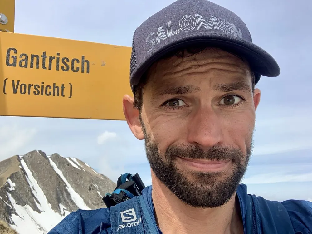 Ramon Krebs next to a Gantrisch trail sign reading “Vorsicht” (caution)